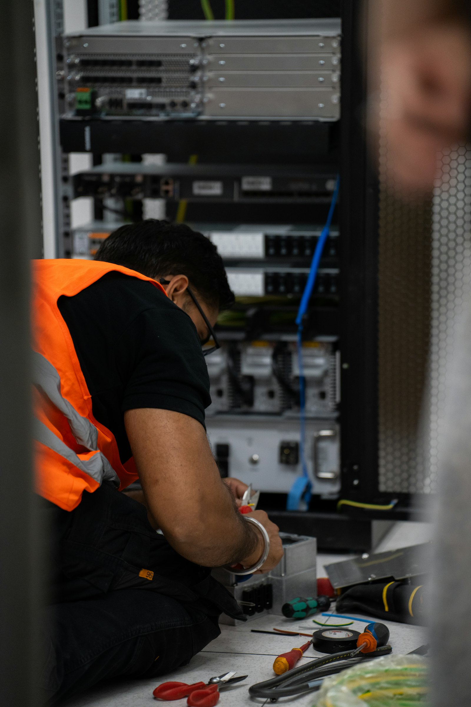Technician in hi-vis working on network equipment